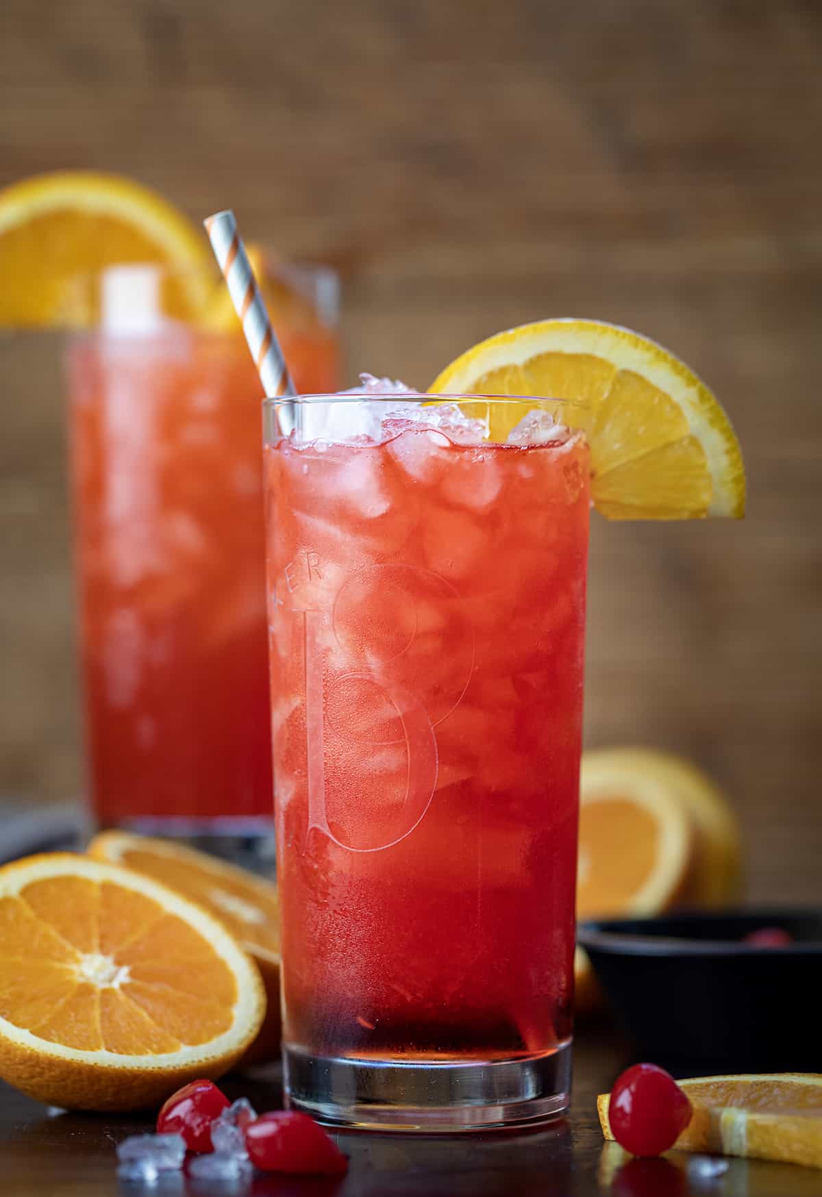 Alabama Slammer Cocktail on a Cutting Board with Oranges and a Straw.