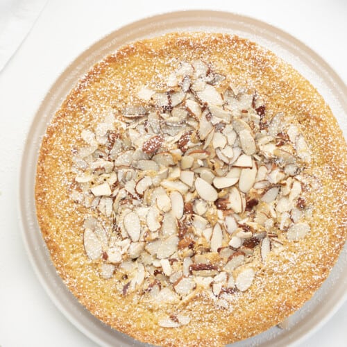 Whole Almond Cake on White Plate Sprinkled with Confectioners Sugar. Almond Cake, French Almond Cake, Moist Almond Cake, How to Make Almond Cake, Almond Cake Recipes, Easy Almond Cake Recipes, Baking, Dessert, Holiday Baking, Christmas Cake, Thanksgiving Cake, i am baker, iambaker