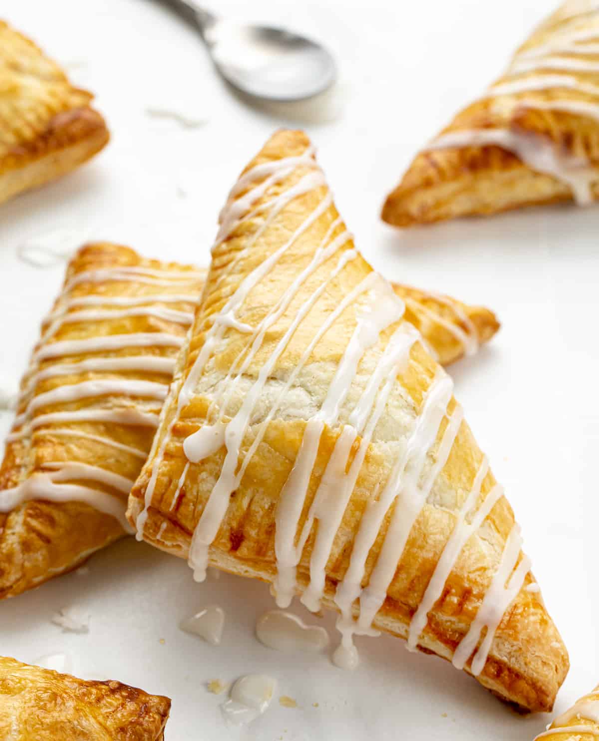 Apple Turnovers on a Counter Drizzled in Glaze.