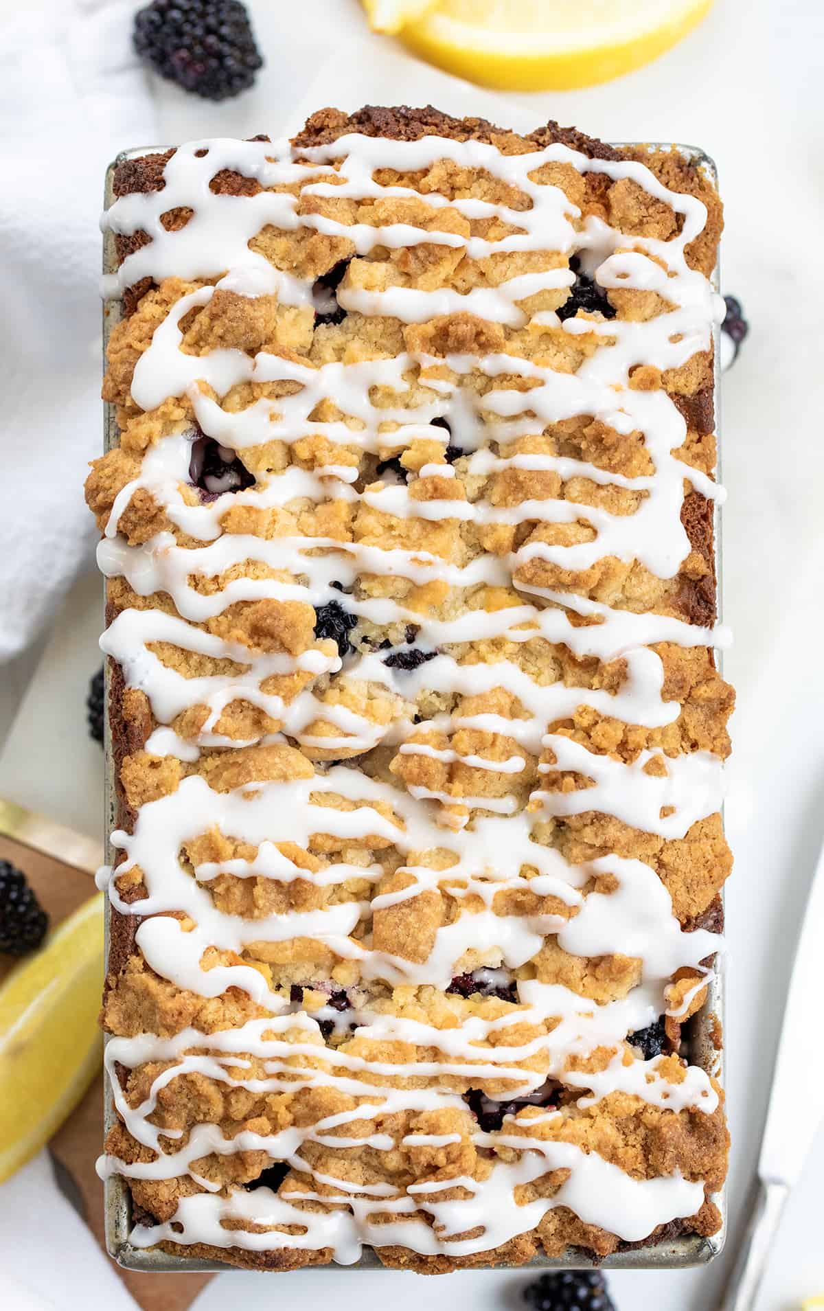 Blackberry Lemon Loaf on a White Counter with Glaze.