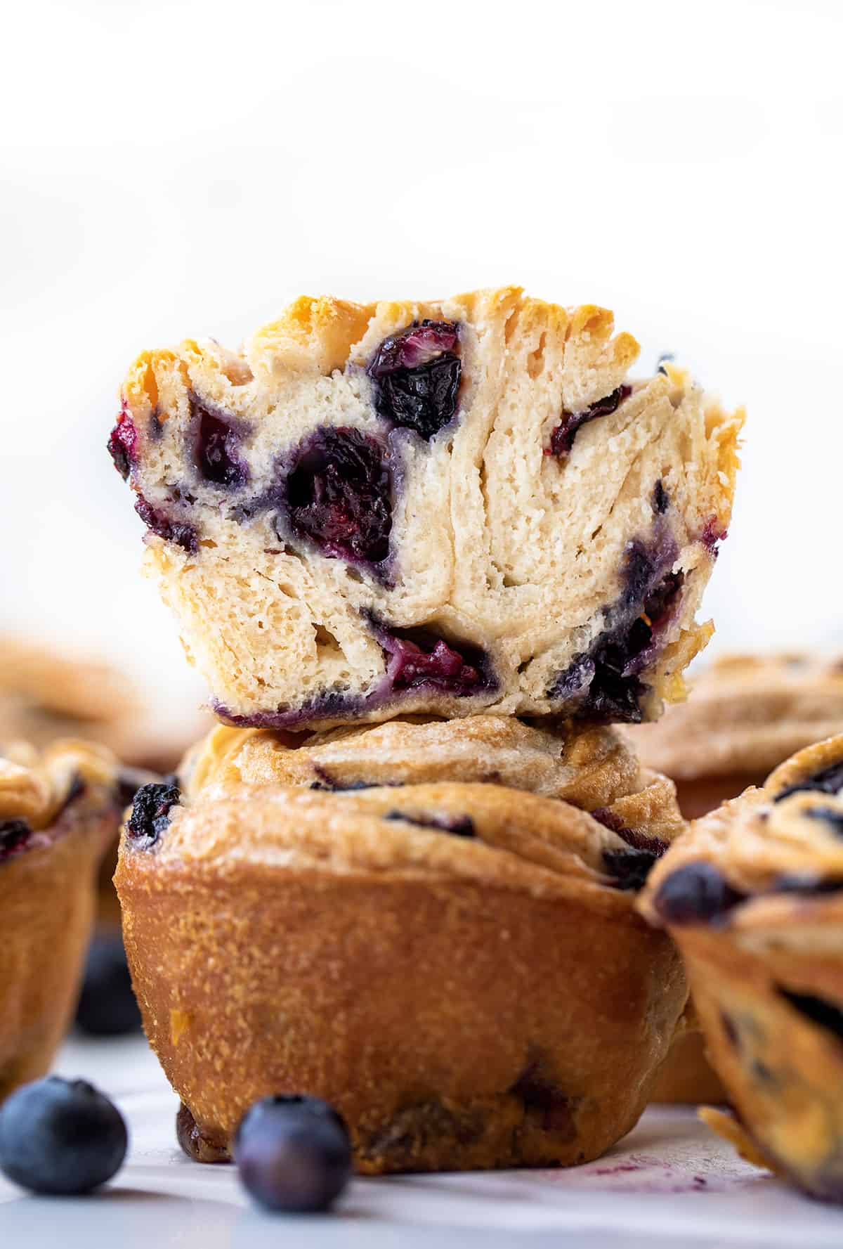 Blueberry Cruffins Stacked and One Cut in Half Showing Inside Texture.