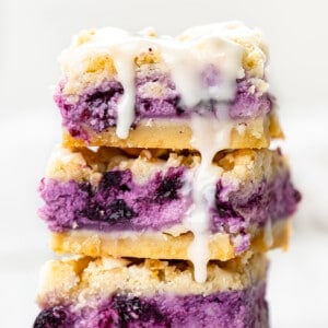 Stack of Blueberry Pie Bars with Glaze Dripping Down. Dessert, Bars, Blueberry Pie Bars, Lemon Blueberry Pie Bars, Summer Desserts, Bar Recipes, Crumble Bars, Blueberry Desserts, Baking, Summer Baking, i am baker, iambaker