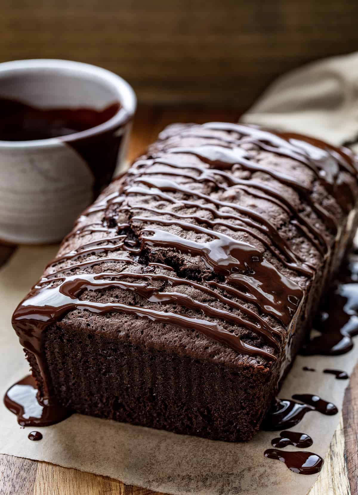 Brownie Bread on a Cutting Board with Chocolate Drizzled Over Top and a Knife. 