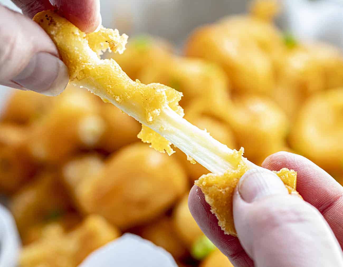 Pulling Apart a Buffalo Cheese Curd with Two Hands