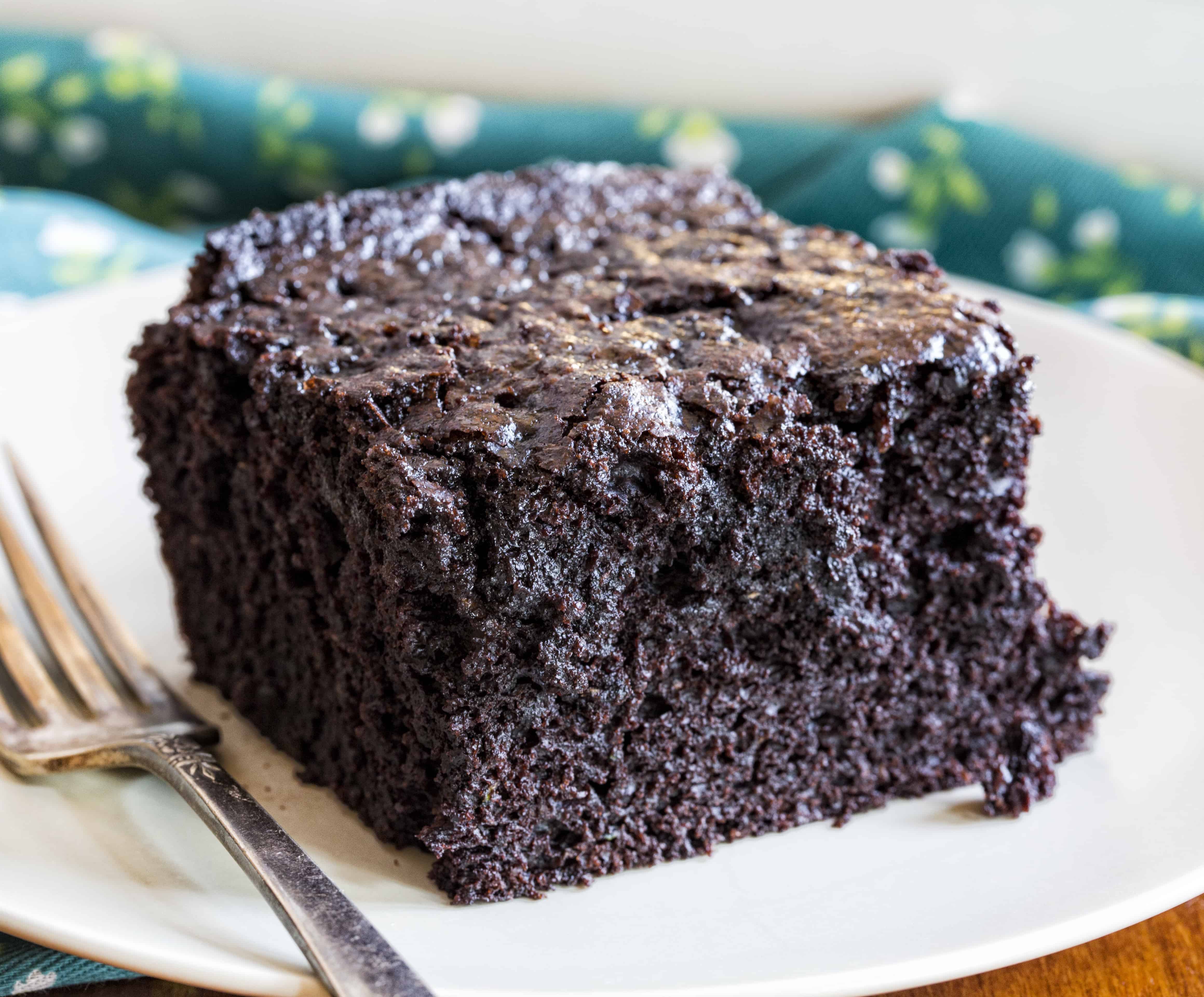 One Piece of Chocolate Zucchini Cake on a White Plate