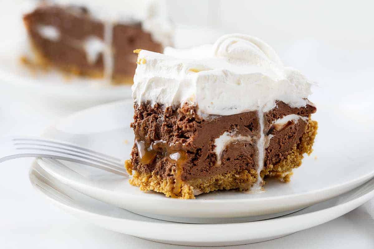 Chocolate Caramel Marshmallow Cheesecake Pie with One Bite Removed Showing Caramel and Marshmallow Inside