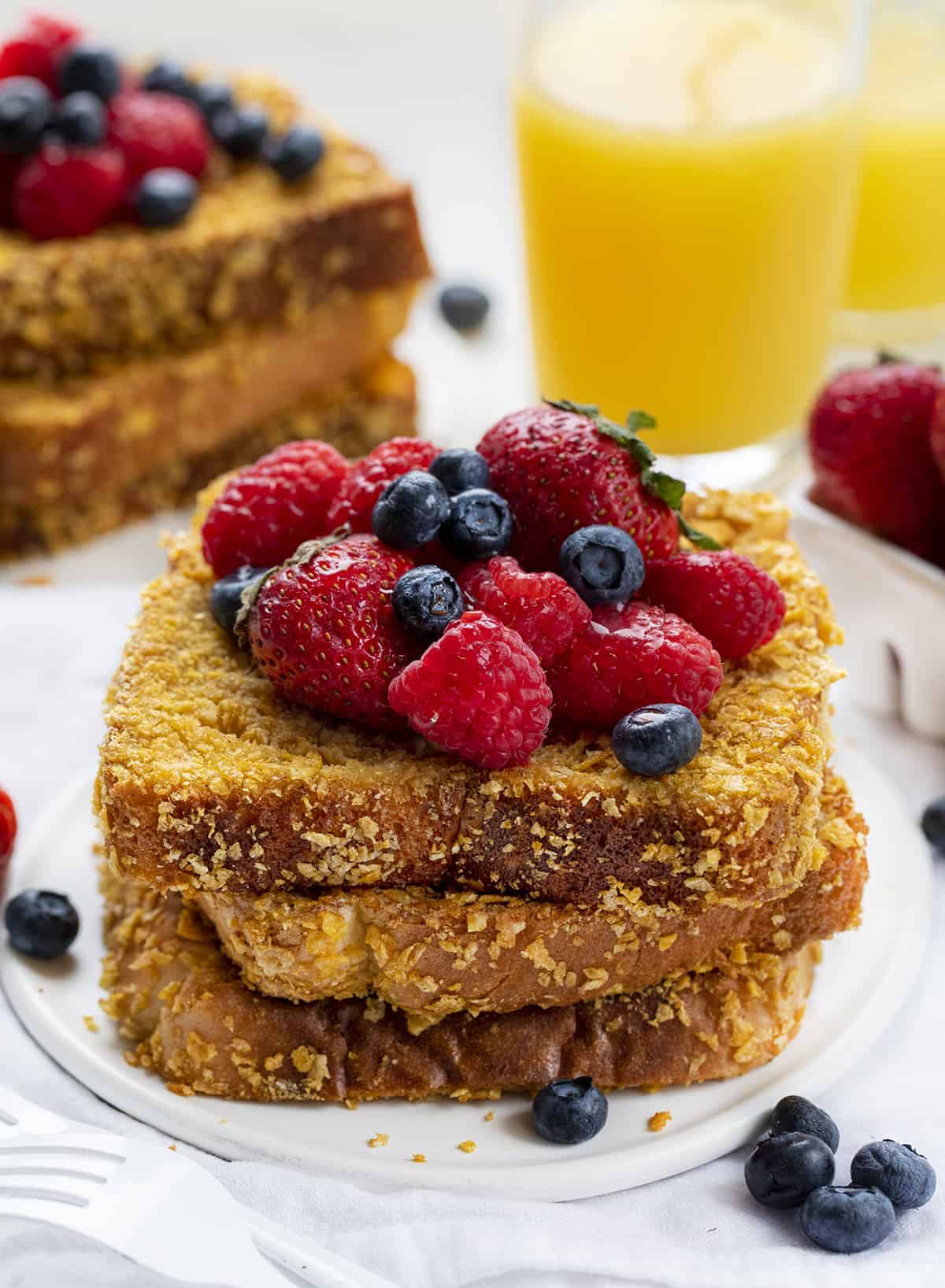 Stacks of Cornflake Crunchy French Toast with Orange Juice and Fruit