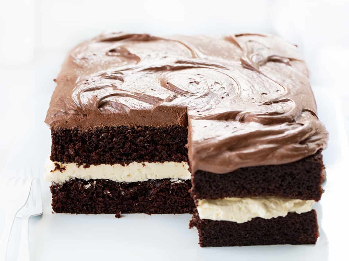 Ding Dong Sheet Cake with Pieces Cut Out Showing Inside on a White Counter.