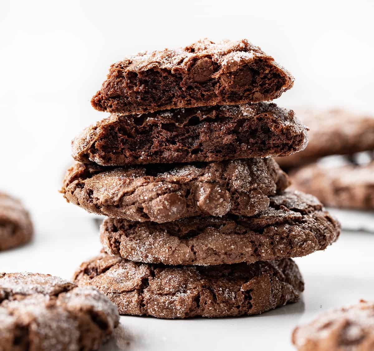 Dirty Chocolate Cookies on a White Counter with One Cookies Broken Showing the Inside Texture. 