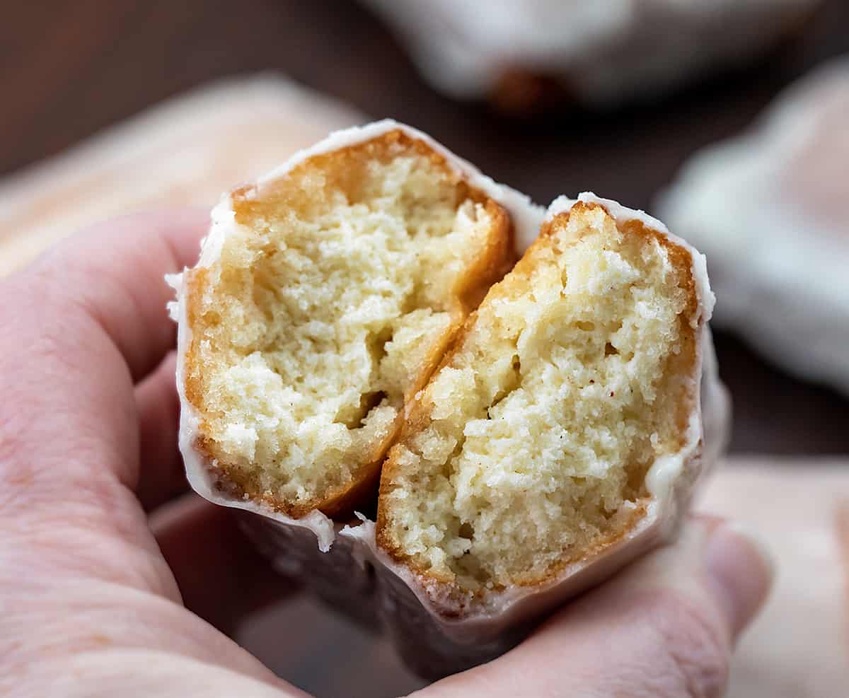 Hand Holding broken in half donut stick showing texture inside.