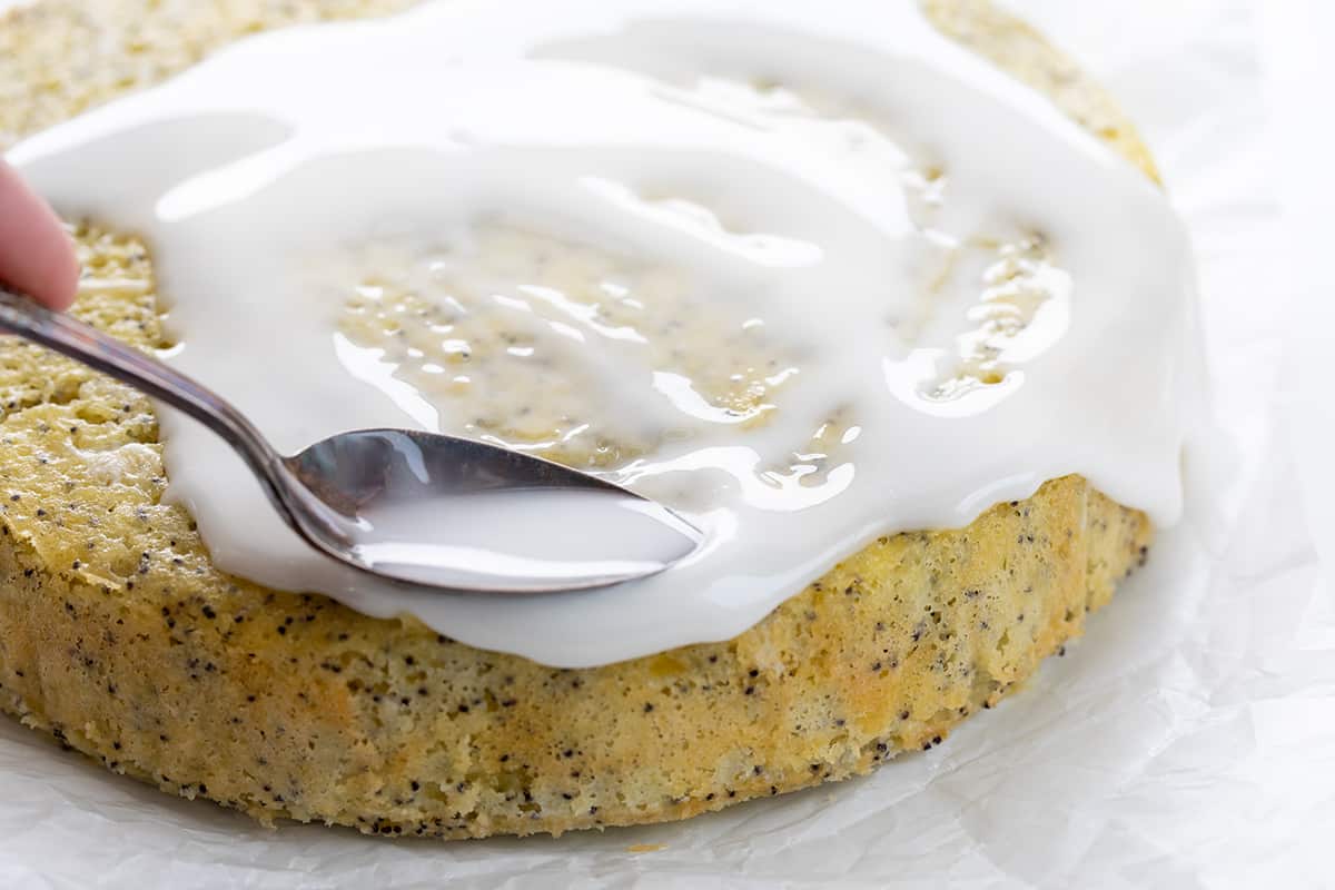 Spreading Glaze Over Lemon Poppyseed Cake.