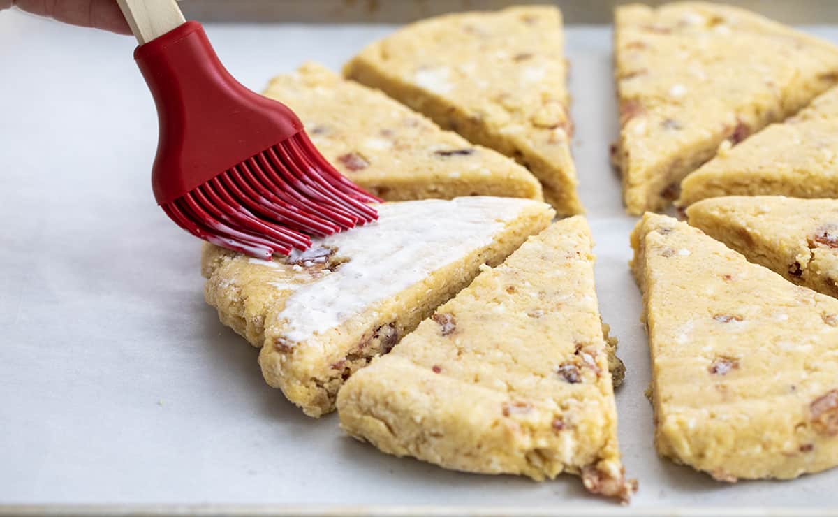 Brushing Milk Over Chilled Maple Bacon Scones Before Baking.