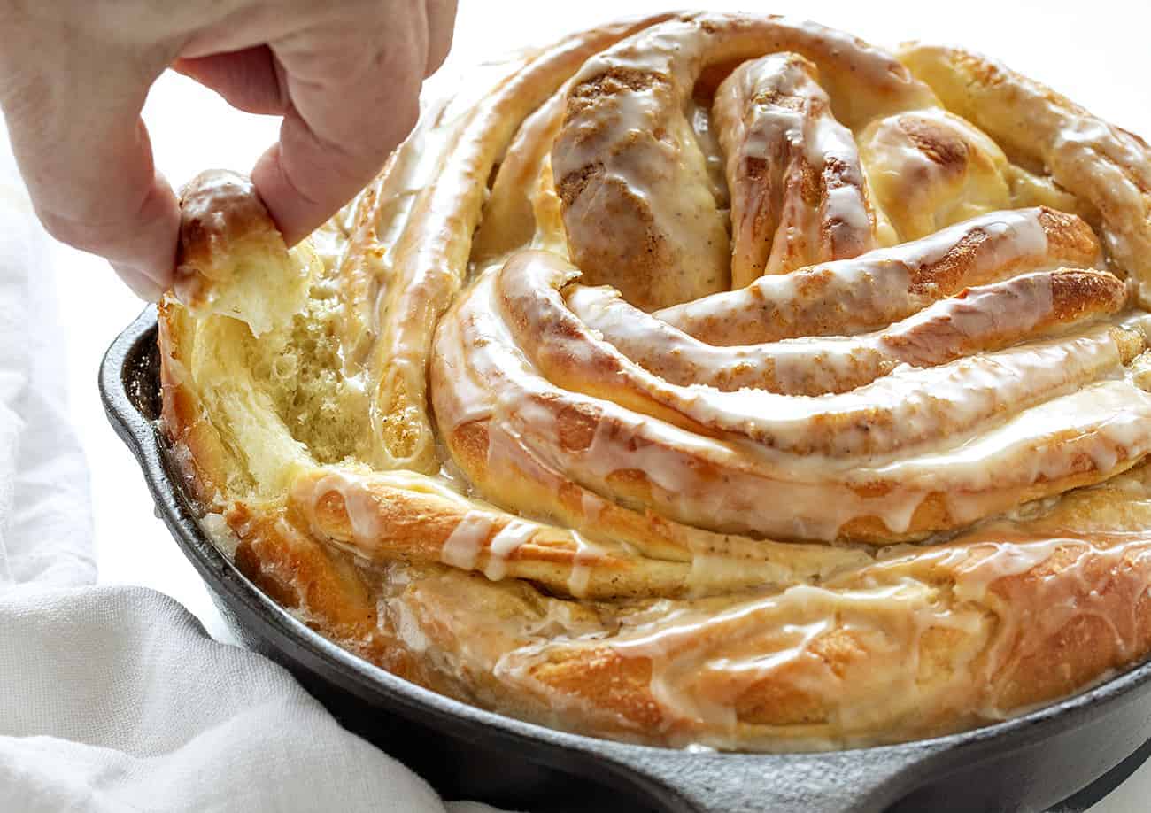 Hand taking some Orange Cardamom Breakfast Bread Twist