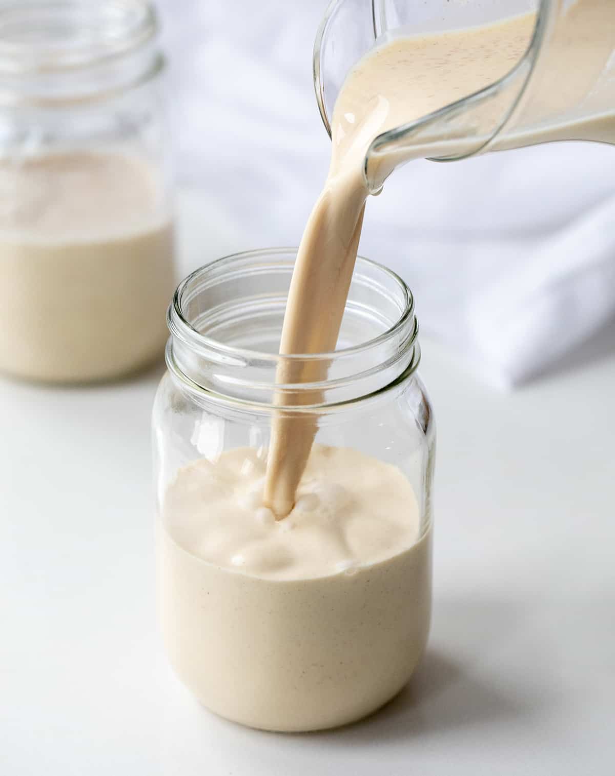 Pouring prepared homemade rumchata to a mug.